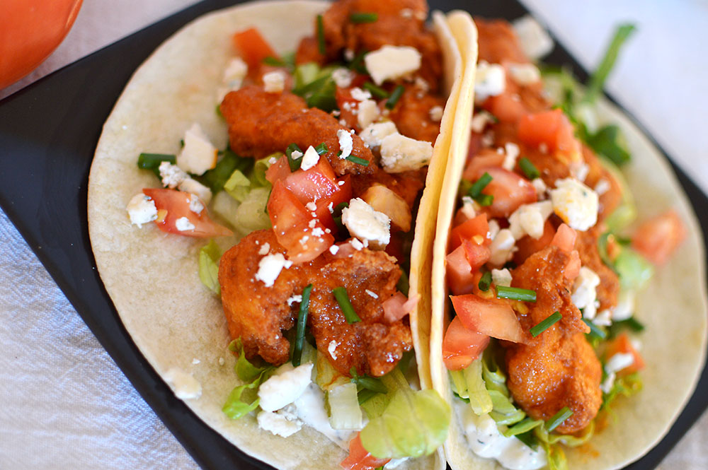 Fried chicken strips coated in spicy buffalo sauce, on a flour tortilla with homemade bleu cheese sauce, tomatoes, lettuce and more bleu cheese.