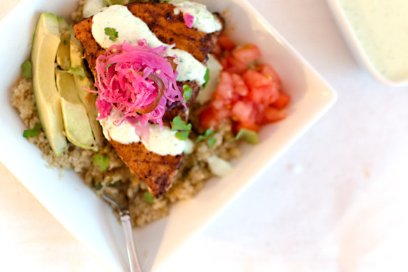 A serrano/garlic quinoa topped with pan-seared swordfish, avocado, tomatoes, a cilantro lime sour cream sauce and pickled goodies on top!